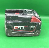 Image of the Milwaukee M28 Red Lithium XC battery pack showing side view with branding and condition.