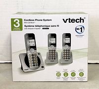 Box of VTech 3-handset cordless phone system showing handsets and base units, model CS5219-3 with call block feature.