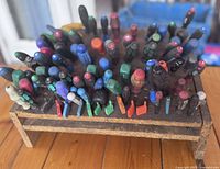 Top view showing a dense arrangement of precision screwdrivers and tools with varied colored handles in a wooden holder.