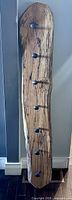 Front view of the spalted maple wood coat rack showing the unique wood grain and black railway spike hooks evenly spaced down the length.