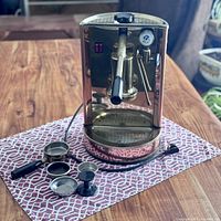 Front view of espresso machine with portafilter, filter baskets and tamper displayed