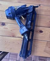 Photo of Prime framing nailer on wooden surface showing overall tool with air fitting and nail magazine.