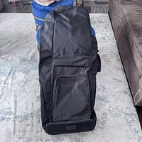 Front view of the black fabric golf bag showing the front pocket and overall structure.