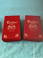 Two red Cartiere Parfums gift boxes side by side
