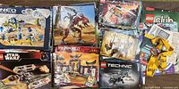 Photo showing a selection of instruction manuals from Lego themes Bionicle, Ninjago, Technic, Star Wars, Mars Mission, and others along with Lego Club cards in mixed condition.