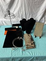 Photo showing mixed jewelry display pieces including velvet necklace busts, metal rotating tree, and cardboard holders