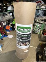 Full roll of Fusion Builder Board surface protector wrapped in plastic with visible product label showing dimensions and branding.