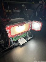 Front view of Craftsman folding work light with one large and one smaller lamp illuminated.