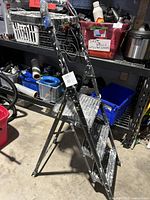 Full view of the three-step Gorilla folding ladder showing its height and condition with surroundings in storage area.