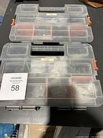 Two closed transparent plastic hardware organizer boxes with orange latches stacked on top of each other.