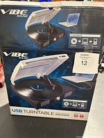 Photo of the original product box showing the Vibe Sound USB Turntable with features and connectivity details.