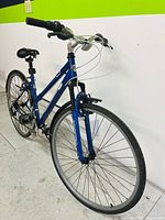 Front angle view of blue CCM Avenue women's bike showing frame, front tire, handlebars, brake cables, and seat.