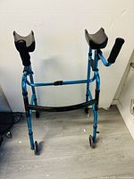 Front view of blue folding wheel walker showing armrest supports and wheels.