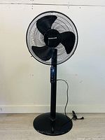 Front view of Honeywell floor standing fan showing round base and black cage fan head.