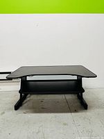 Front view of the small portable study table for kids showing the slanted tabletop and a narrow shelf underneath.