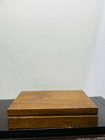 Wooden box closed, top view showing wood grain and slight wear, used for storing flatware set
