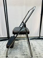 Side view of vintage Cosco foldable 2-step ladder showing metal frame, steps and handle