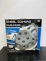 Front view of the KCT 16-inch wheel cover in original black and blue box with product name and partial vehicle graphic.