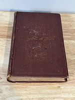 Front cover of the antique hardcover book showing brown textured cover with gold embossed title and signature 'John B. Gough'.