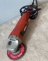 Full angle grinder including wheel, showing condition and color (red with black parts).