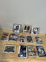 Mixed set of hockey, baseball, Pokemon, and DC Comics trading cards laid out on a wooden surface.