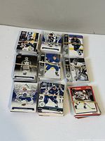 Top-down image showing nine stacks of hockey cards grouped with rubber bands, featuring players from various NHL teams.