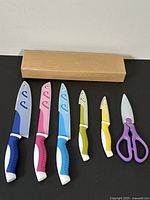 Photo showing all six cutting tools arranged next to a cardboard box.