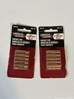 Two packages each containing 10 Lincoln Electric .035" (0.9mm) contact tips KH712 on original red packaging cards, total 20 tips.