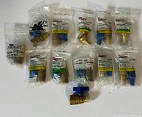 12 Sioux Chief Tomahawk valves in sealed packages, blue handles, brass bodies, mixed sizes including 1/2 inch, 3/4 inch, 3/8 inch