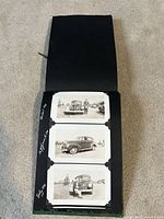 Photo showing black vintage photo album open to a page with three black and white photos of vintage cars with handwritten dates July 1941 and March 1941.