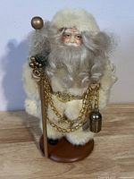 Front view of vintage Santa Claus figurine showing full figure with cream fur trim and gold chains, standing on wooden base