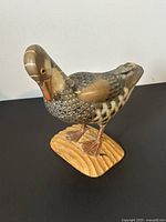Side view of the vintage hand carved wooden duck figurine on a wooden base, showing detailed paint and carved feathers.