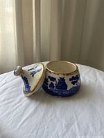 Porcelain container with lid removed showing interior, blue and white design, gold trim