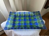 Braided blue and green glass tray showing top woven pattern and color.