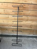 Front view of the black metal wall-mounted wine rack with seven pairs of horizontal holders