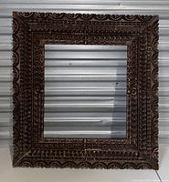Front view of vintage wooden frame showing ornate carved wood detail in a square shape