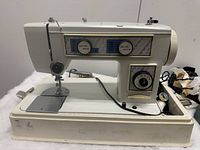 Off-white Emdeko sewing machine with stitch selection dials and needle platform.