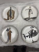 Four Erte Franklin Mint decorative plates arranged together showing different Art Deco style female figures.