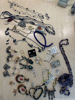 Overview of various necklaces, bracelets, earrings, and clips spread on table.