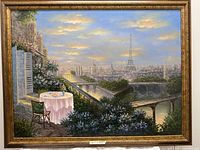 Front view of the large framed painting depicting the Eiffel Tower from a terrace with flowers and river view at sunset.