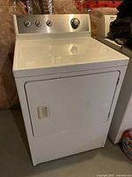 White Amana clothes dryer with control panel and door handle photographed from front.