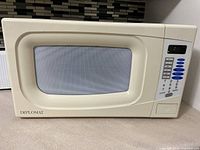 Photo of a cream-colored Diplomat microwave oven, showing front and control panel with numeric keypad and timer buttons.