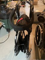 Folded Walker Nexus folding walker showing padded handles and wheels.