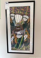 Framed linen artwork showing colorful abstract masked figures