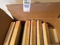 Eight volumes in original shipping box showing cloth-bound beige spines with paper labels