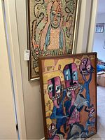 Two framed textile artworks: Prince Twins Seven Seven piece in background and tufted panel in foreground