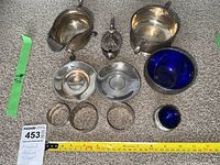 All nine pieces arranged on carpet: gravy boat, mustard pot, two bottle coasters, three napkin rings, large cobalt bowl, small cobalt dish