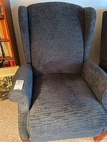 Front view of dark gray upholstered wingback recliner