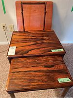 Overview showing two nested wood tables, wood TV tray top leaning behind, and freestanding towel holder