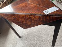 Front-left view showing triangular top panel and drop leaf hanging down